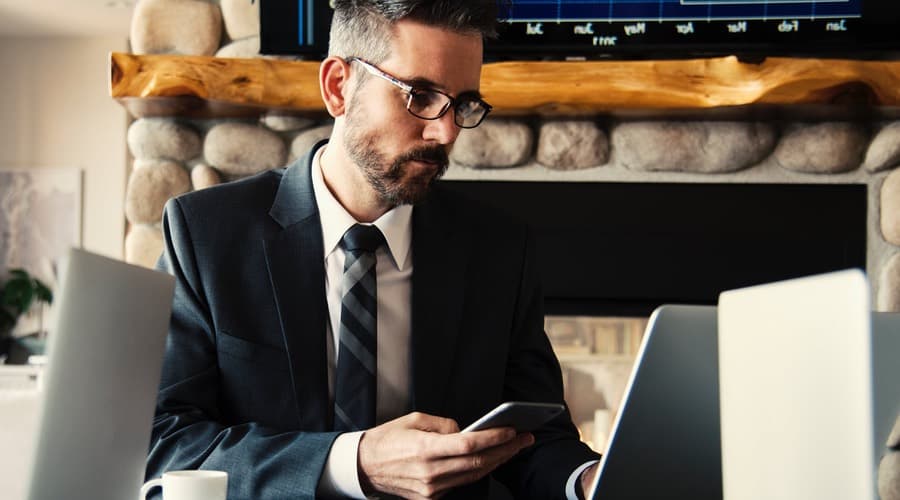The picture shows a man that is working with his mobile in the hand and his laptop on the desk. he wears glasses. Those situations are optimally for the Shamir Autograph Intelligence.